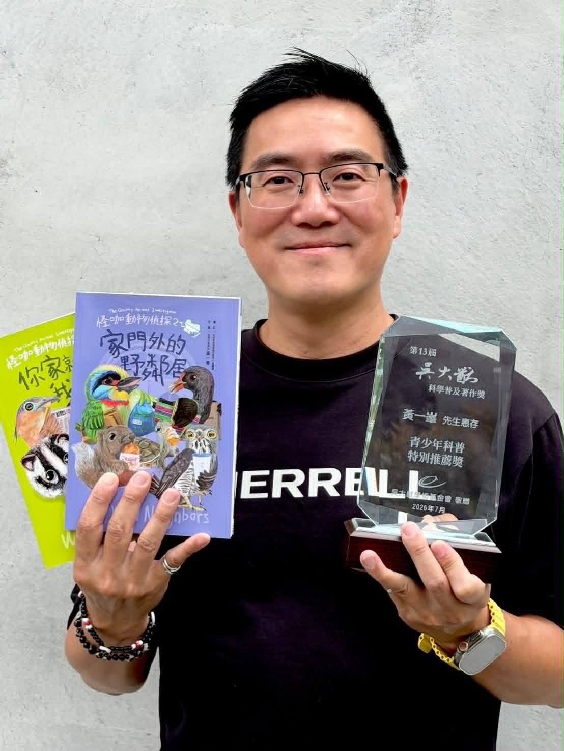 黃一峯老師手持科普著作與第13屆吳大猷科學普及著作獎獎座